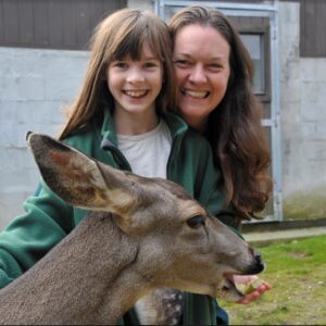 Erin and her younger child feeding a deer